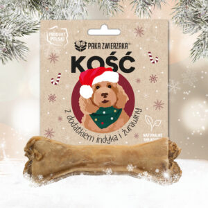 Kość dla psa Paka Zwierzaka z dodatkiem indyka i żurawiny - naturalny przysmak w świątecznym opakowaniu z rysunkiem psa w czapce Mikołaja, na tle zimowych gałązek i śniegu.